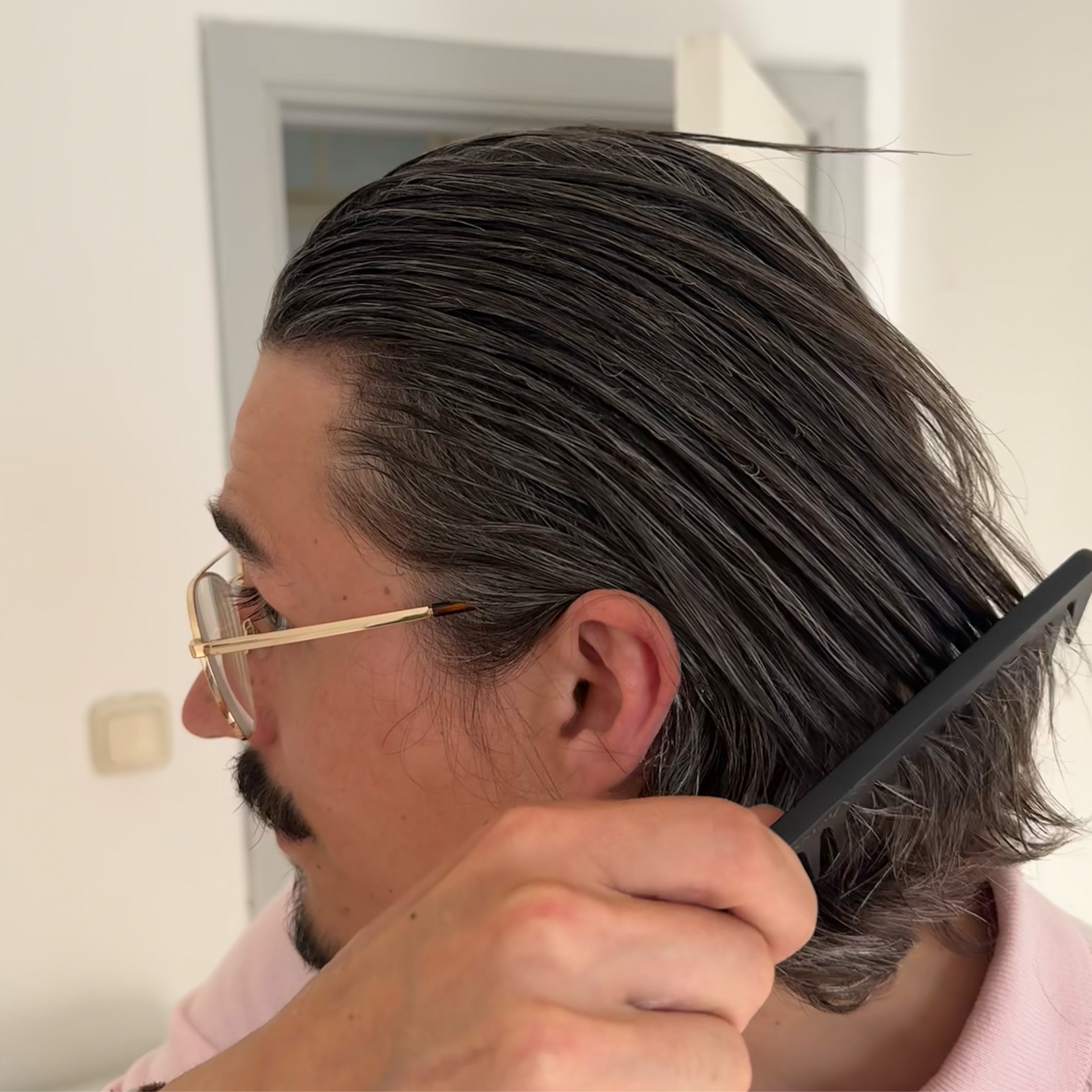 Merten arbeitet die Haarcreme mit dem Kamm ein